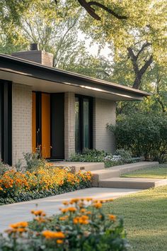 a house with orange flowers in front of it and trees around the outside area on either side