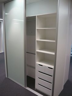 an empty white closet with shelves and drawers