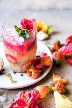 a close up of a drink on a plate with flowers in the backgroud