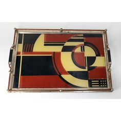 an art deco tray with geometric design on it, in red and yellow colors is shown