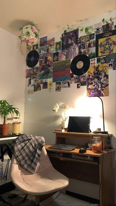 a room with a desk, chair and various pictures on the wall above it that are covered in vinyl records