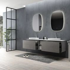 a bathroom with two sinks and mirrors on the wall