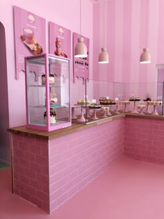 a pink and white bakery with cupcakes on display