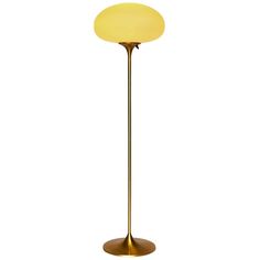 a floor lamp with a yellow light on it's side and a white background