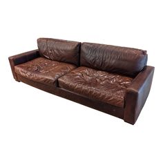 a brown leather couch sitting on top of a white floor