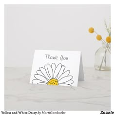 a thank you card with a daisy in a vase on a marble countertop next to it