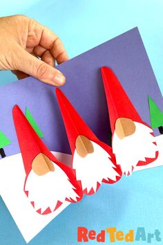 a hand is pointing at three paper gnomes