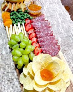 an assortment of fruits and vegetables are arranged on a platter with dips, crackers, and fruit