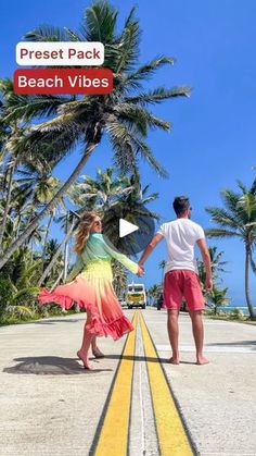 a man and woman walking down the road holding hands with palm trees in the background