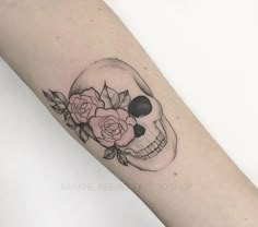 a skull and roses tattoo on the arm