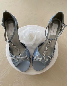 two pairs of blue high heeled shoes sitting on top of a white plate