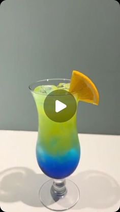 a colorful drink with an orange slice in it