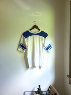 Up for sale is a vintage 1960's to 1970's Dodgers Sportswear "Lakers" athletic style shirt with beautiful graphics on the front and sleeves. Overall the garment is in good condition with no major rips or tears. There are some various faded spots of discoloration though no egregious stains exist (see photos for noted flaws). Dodger Sportswear 50% cotton 50% polyester Tag size: M Estimated size: S to M Measured flat (inches across): Length (back bottom of collar to bottom hem): 23 1/2 Pit to pit: Affordable Vintage T-shirts For Sports Season, Womens Vintage Workout Shirt, Retro College T-shirt With Screen Print, Collegiate Three Stripes Short Sleeve T-shirt, Varsity Style Crew Neck Top With Three Stripes, Vintage White Crew Neck Shirt, Retro Sports Crew Neck Top, Retro Sports Tops With Crew Neck, Retro Crew Neck Sports Top