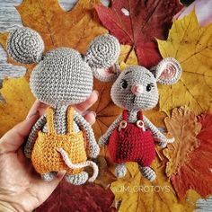 two crocheted mice holding hands in front of autumn leaves