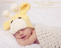 a baby is wearing a knitted hat with a giraffe on it