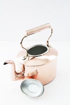 a tea pot and saucer sitting next to each other on a white table top