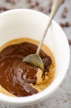 a spoon in a bowl filled with peanut butter and chocolate