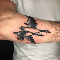 a man's arm with a black and white duck tattoo on it