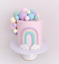 there is a pink cake with a rainbow on it