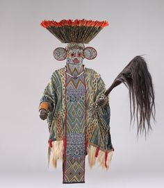 an elaborately decorated headdress with feathers on it's face and tail