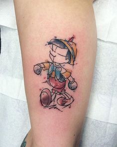 a cartoon character tattoo on the right arm and leg, with an outline of a baseball player holding a ball