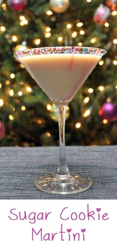 a sugar cookie martini in front of a christmas tree with the words sugar cookie martini on it