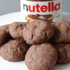 chocolate cookies and nutella spread on a white plate with a jar of nutella in the background