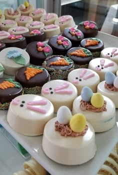 there are many decorated cupcakes on the table with bunny ears and carrots