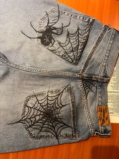 a pair of jeans with spider webs on them