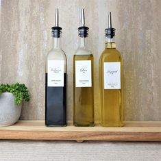 three bottles of olive oil sitting on a shelf