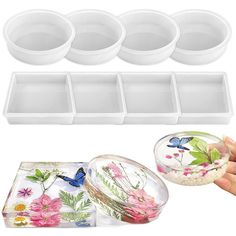 four plastic containers with flowers and butterflies on them, one is open to reveal the lids