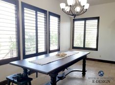 an empty dining room with large windows and wooden shutters