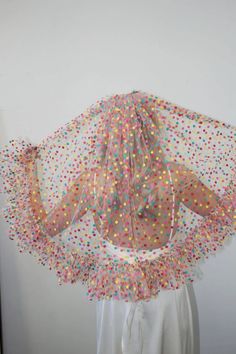 an umbrella with multicolored confetti on it is hanging from the ceiling