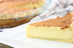 a piece of pie sitting on top of a white plate next to a glass bowl