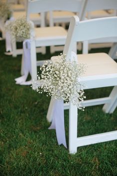 the chairs are decorated with baby's breath flowers and ribbon tied at the back