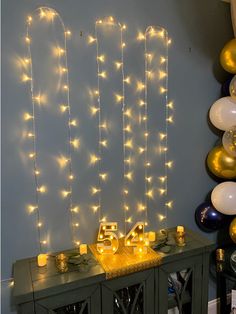 a table with candles and balloons in front of the number twenty five sign on it