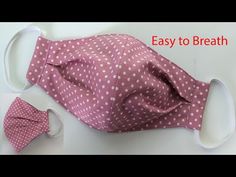 a pink and white polka dot cloth face mask with matching bow tie on the side