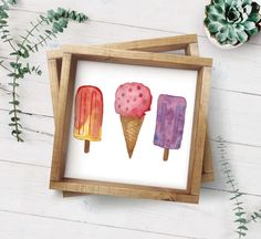 three ice creams are in a wooden frame