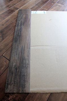 a piece of cardboard sitting on top of a wooden floor