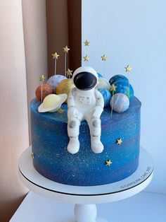 an astronaut cake with stars and planets on it