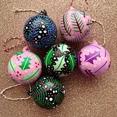 four decorated christmas balls on a table with twine string and decorations hanging from them