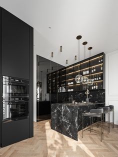 an elegant kitchen with marble counter tops and black cabinets, along with stainless steel appliances