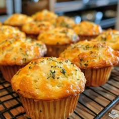 several muffins cooling on a rack in the oven, with herbs sprinkled on top