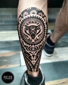 a man's leg with a black and white tattoo design on the calf area