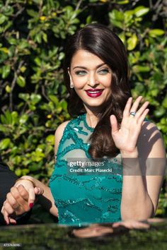 a woman in a green dress waving at the camera