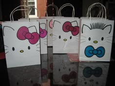 three hello kitty bags sitting on top of a table