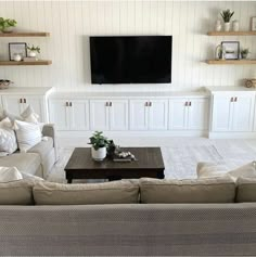 a living room filled with furniture and a flat screen tv mounted on the wall above it