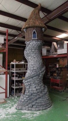 a building made out of rocks with a thatched roof and chimney on the top