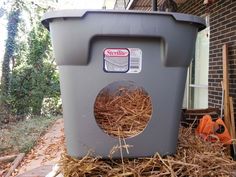 a grey trash can sitting on top of hay