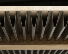 a close up view of the top of a wooden shelf with metal bars on it